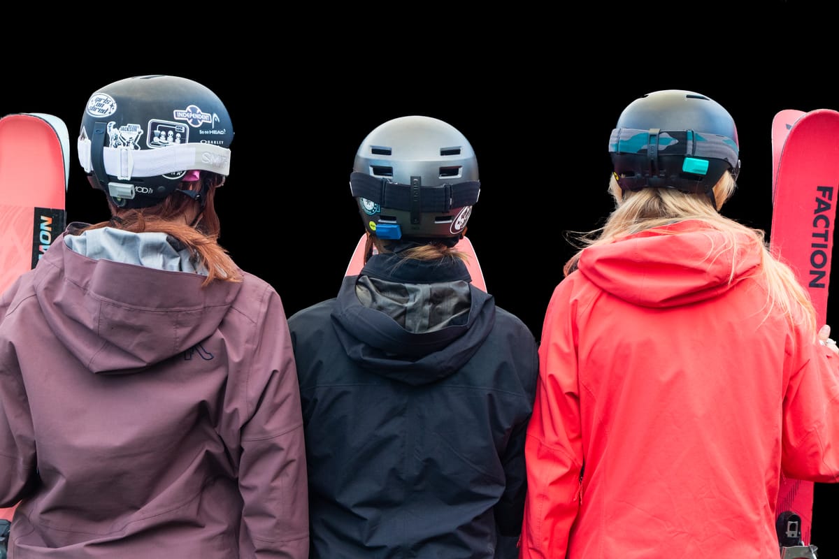 Three skiers seen from behind, each with a Noggin sensor mounted on their helmet