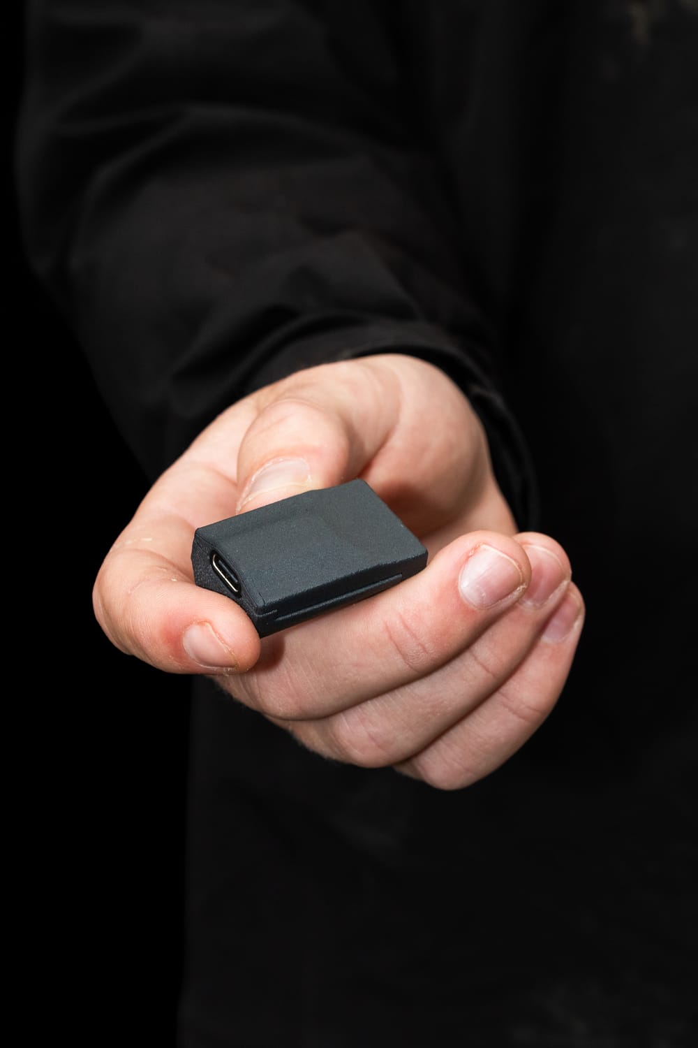 A hand holding out a single Noggin sensor